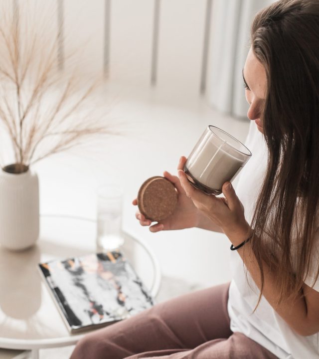 russian-girl-sitting-chair-smelling-candle-scaled.jpg